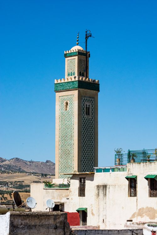 Free A beautiful minaret in a cityscape with clear sky, showcasing exquisite Islamic architecture. Stock Photo