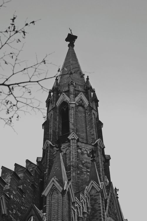 Free Striking black and white photo of a gothic cathedral tower with intricate architectural details. Stock Photo