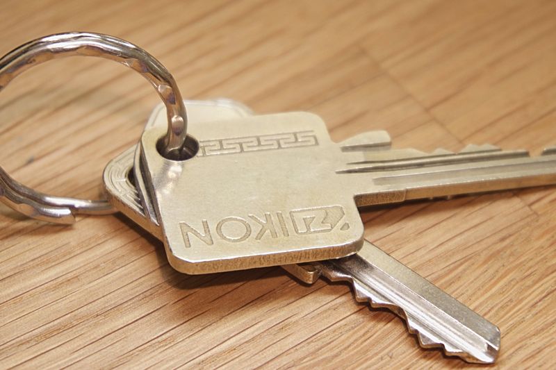 A set of metal house keys on a wooden surface, ideal for real estate themes.