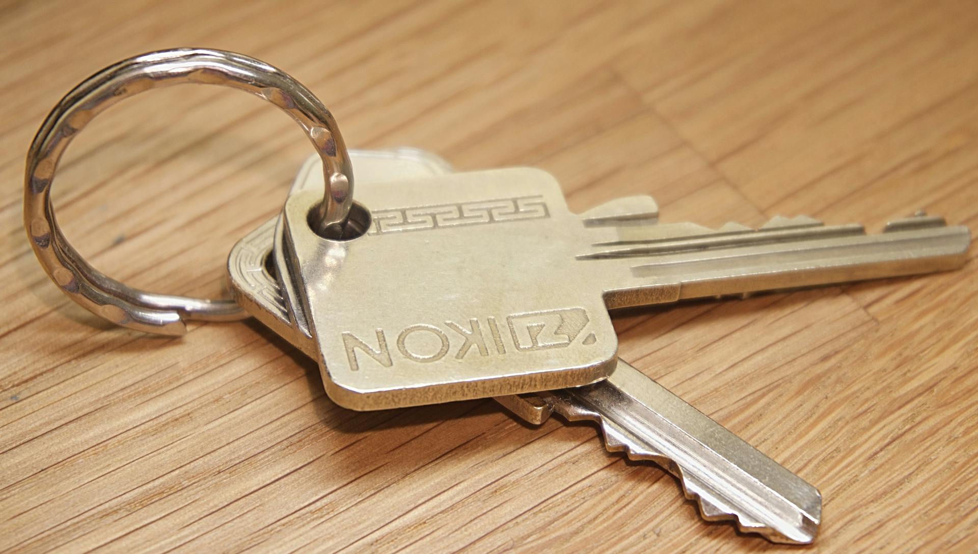 A set of metal house keys on a wooden surface, ideal for real estate themes.