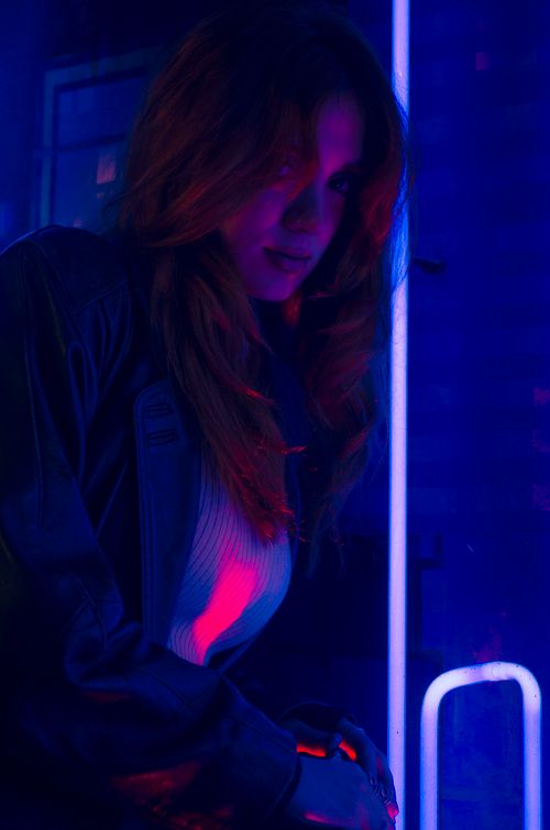 Free Captivating portrait of a woman bathed in neon lights, creating a mysterious and vibrant atmosphere. Stock Photo
