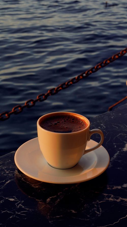 Free Serene coffee moment on a marble table by the Bosphorus in Istanbul at sunset. Stock Photo