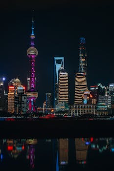 Stunning view of the Shanghai skyline featuring illuminated skyscrapers reflecting on the water at night.