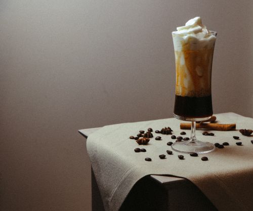 Free Elegant iced coffee with whipped cream on a table, offering warm tones and cozy ambiance. Stock Photo
