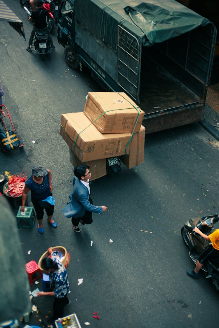 People Walking Near Boxes And Truck On Street