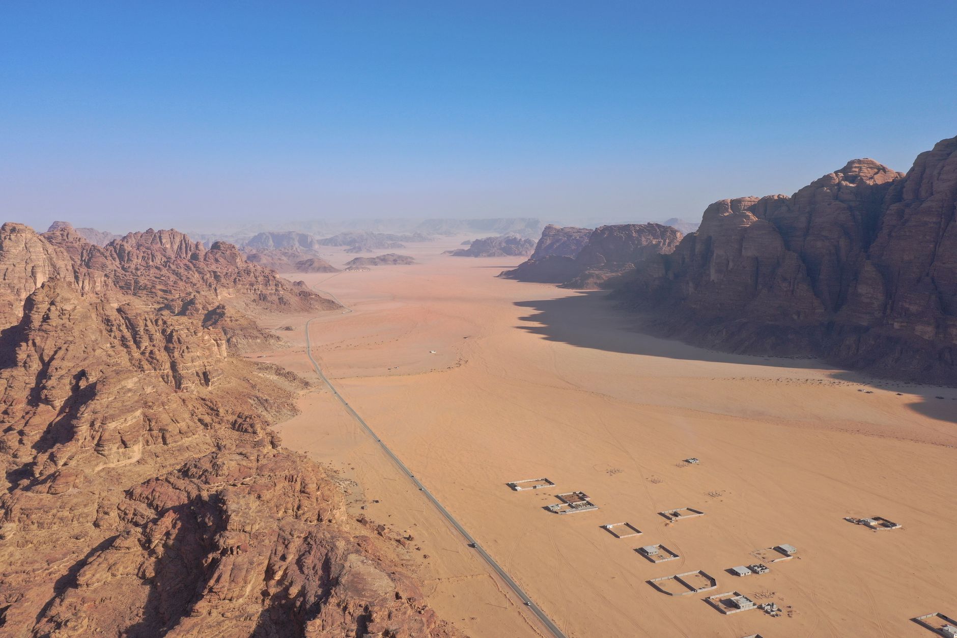 旅行後照片整理一日完成:AI輔助簡單法 Stunning aerial view of Wadi Rum's expansive desert landscape in Jordan, featuring rock formations and clear blue skies.