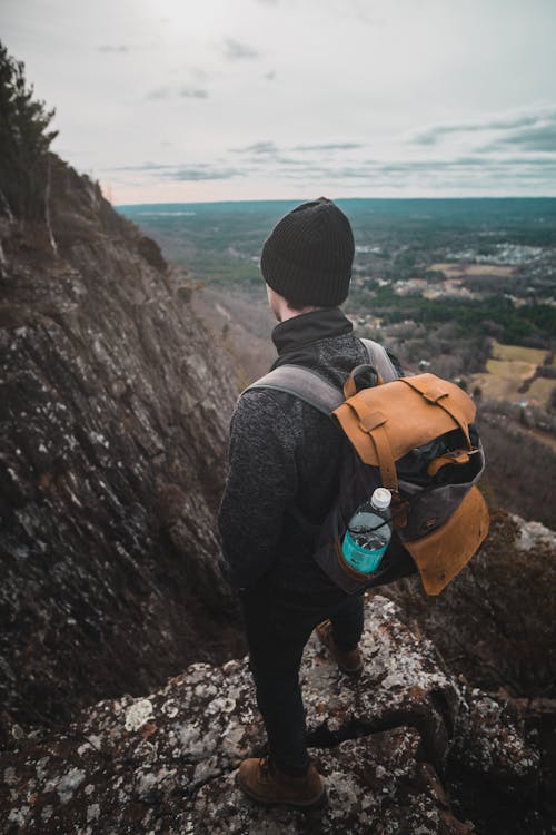 Back View of a Hiker Standing on the Cliff Edge