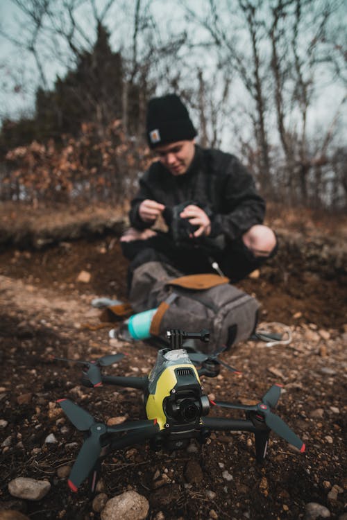 Man Crouching in a Forest with a Drone 