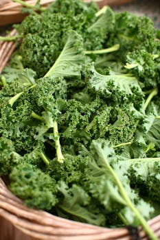 Close-up of fresh green kale leaves in a rustic basket, emphasizing health and nutrition.