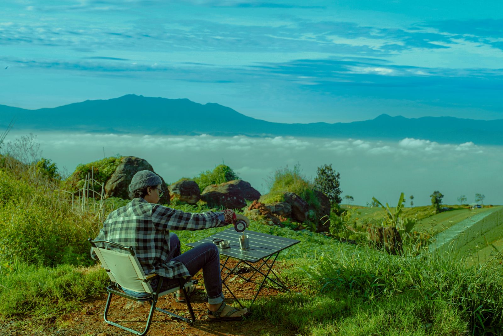 Man relaxing with coffee on a mountain slope representing relaxed Easy Rider coffee stops