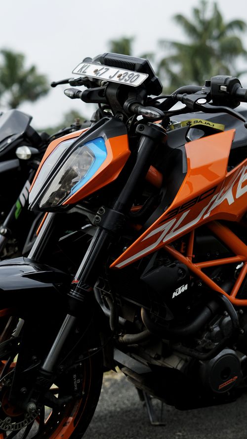 Free Dynamic close-up of a sleek orange motorcycle with bold livery in outdoor setting. Stock Photo