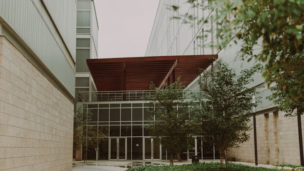 A view of modern architecture framed by greenery in Kuwait City.