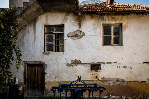 An Abandoned House with Broken Glass Windows 