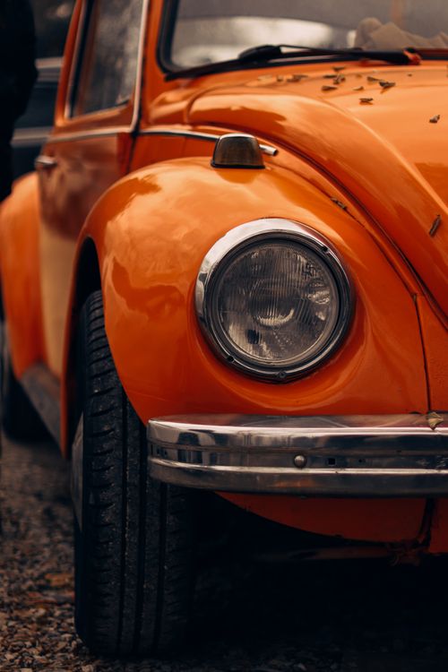 Free Detail view of a classic orange car with shiny chrome features. Stock Photo