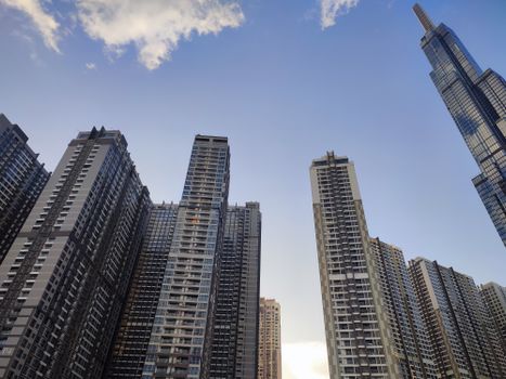 Low angle view of urban skyscrapers under a blue sky during the day.