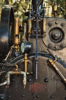 Close-up view of antique steam engine machinery with brass pipes.