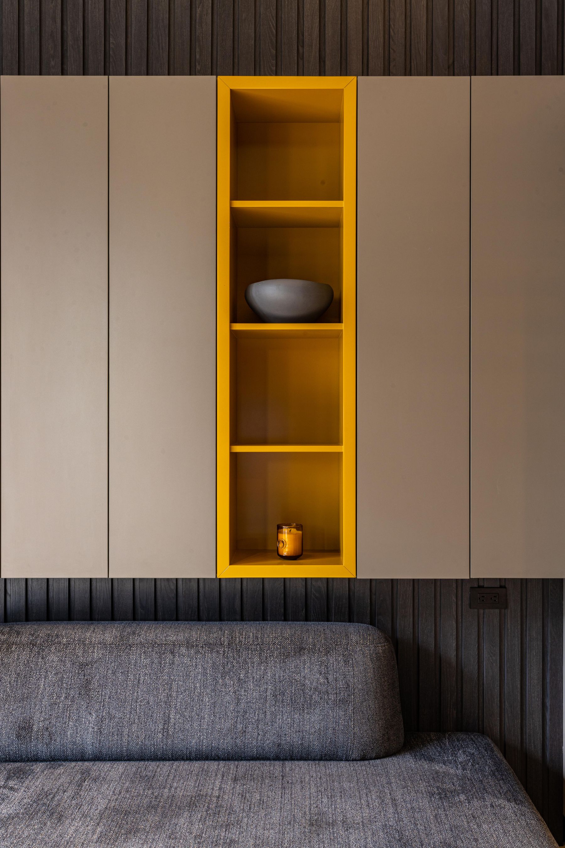 Living room with a long low storage unit, wall shelves and a television