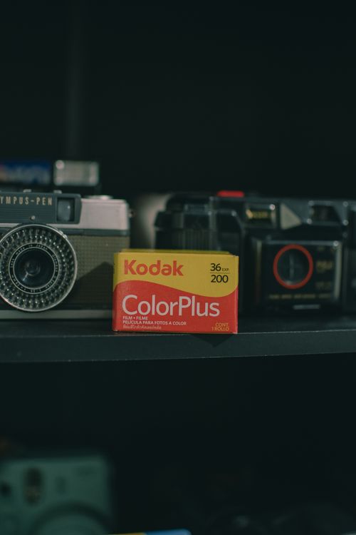 Free Collection of vintage cameras with a Kodak ColorPlus film box in focus. Perfect for photography enthusiasts. Stock Photo