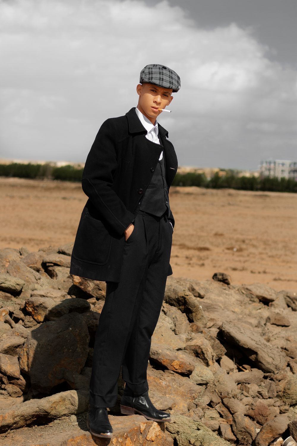 A man in a suit and hat standing on rocks · Free Stock Photo