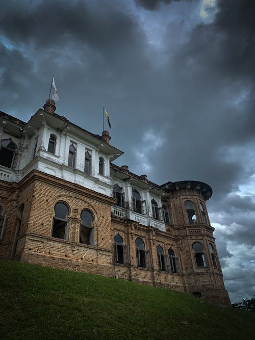 Old Brick Castle on Hill against Cloudy Storm Sky
