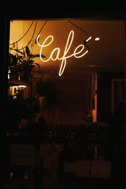 Free Illuminated café sign with warm, cozy ambiance at night in Goiânia. Stock Photo