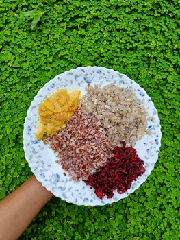 Plate of traditional Indian food held against a lush green backdrop in Taliparamba.