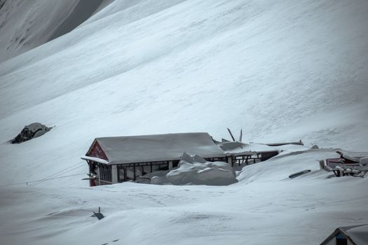 A solitary building buried under snow, illustrating the aftermath of an avalanche.
