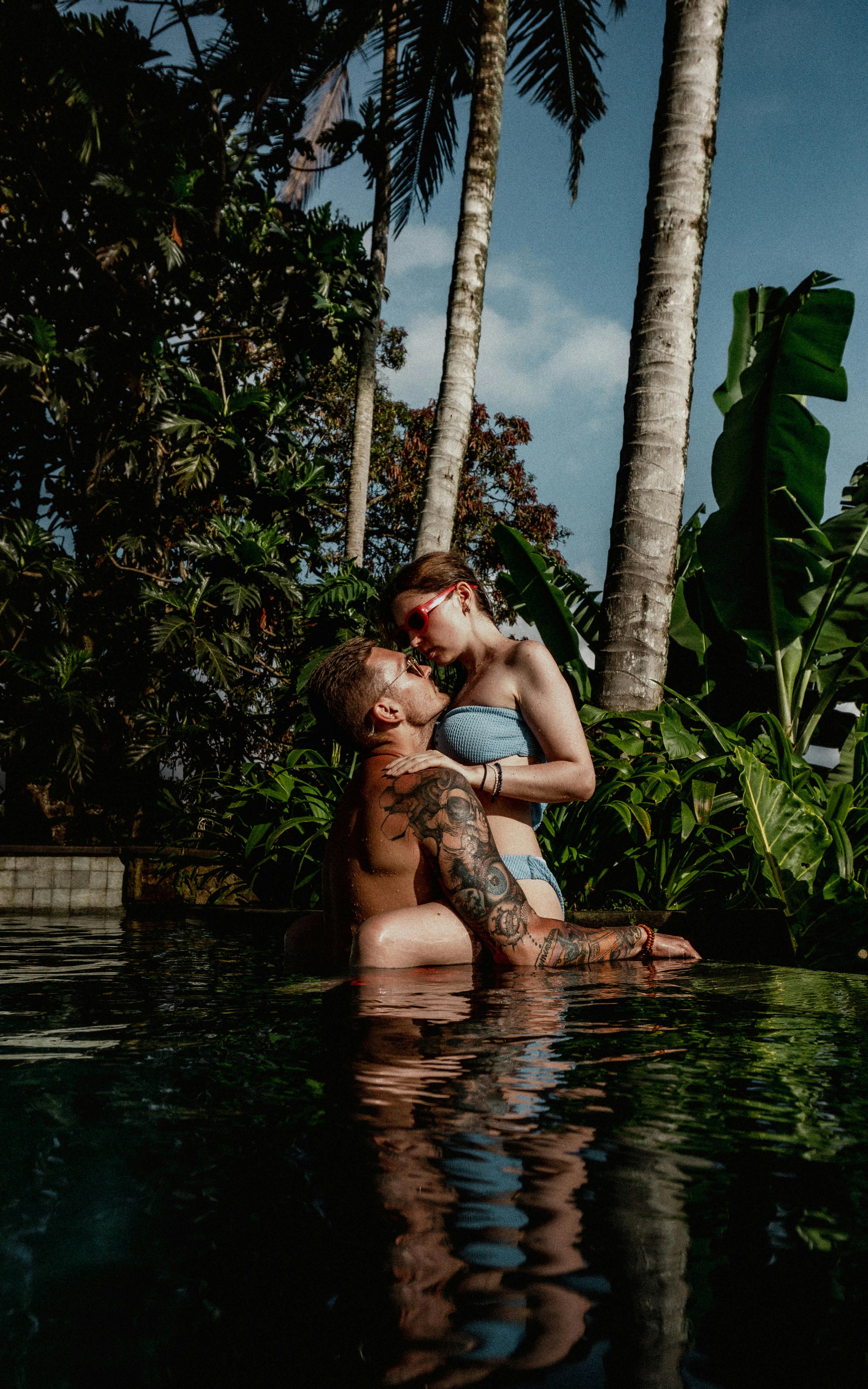 Premium Photo | A couple swims in a pool with the sun shining on their  faces.