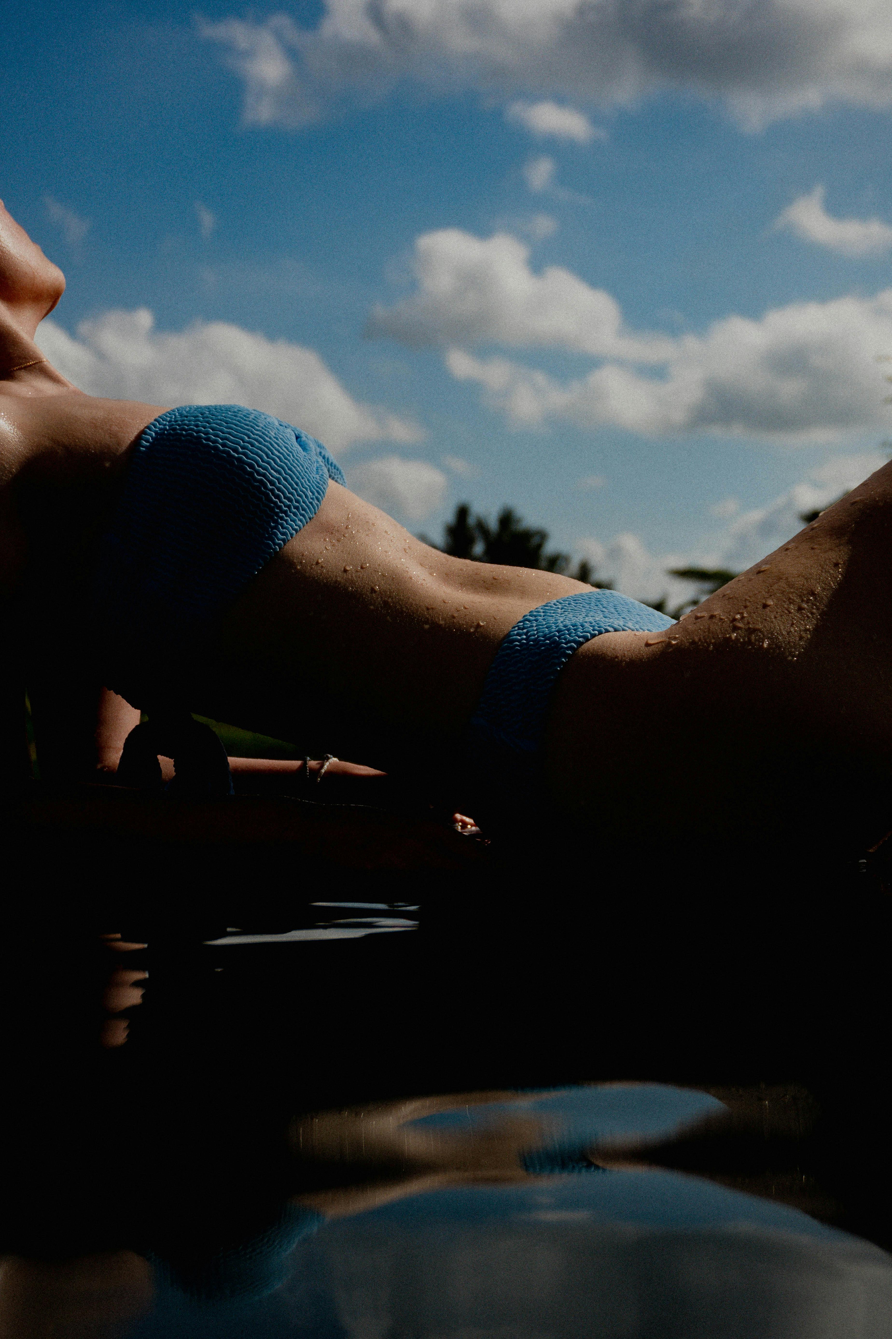 一名身穿蓝色比基尼的女子在户外享受阳光明媚的一天