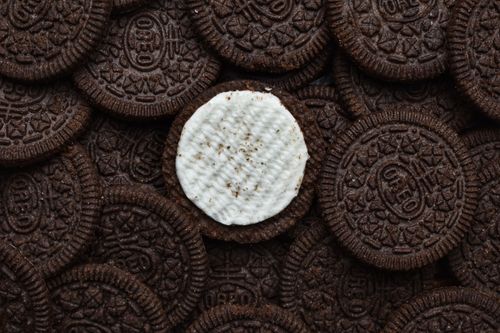 Free Delicious chocolate cream cookies stacked together with one missing cream top. Stock Photo