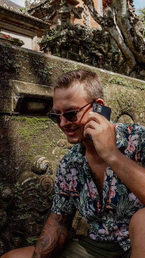 Smiling Man in Sunglasses Talking on Cellphone Outdoors