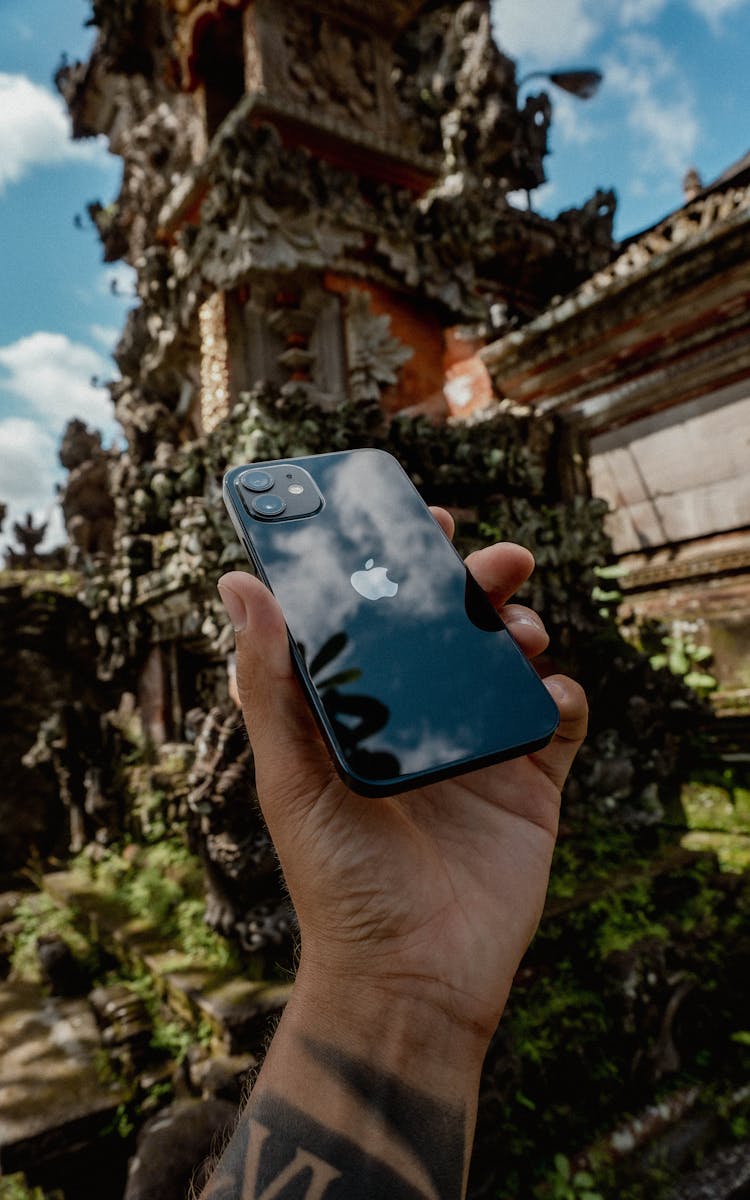 Man Hand Holding Modern Cellphone On Old Castle Background