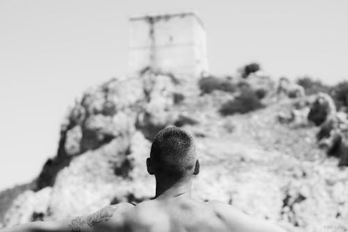 Back View of a Shirtless Man Looking the Mountain