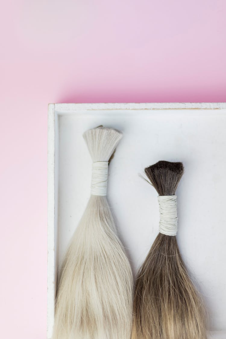 Bundles Of Hair Extensions On Pink Background