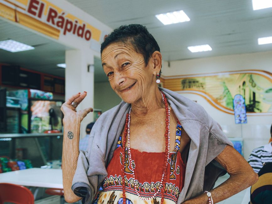 Retrato de uma mulher idosa sorridente em um café.