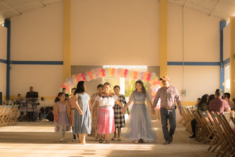 People Walking And Holding Hands In Hall