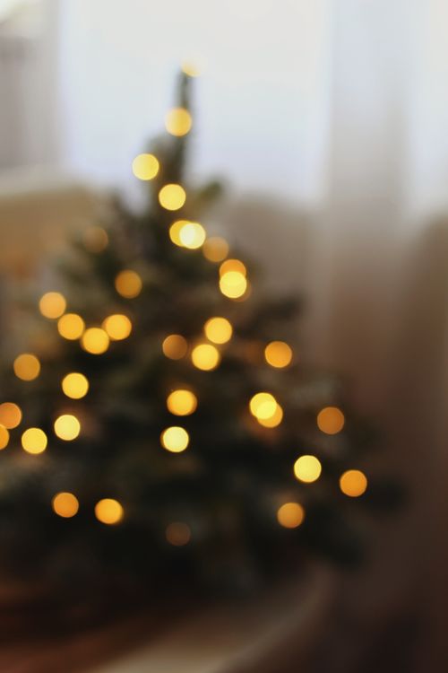Free A cozy blurry Christmas tree with glowing lights creating a festive atmosphere. Stock Photo