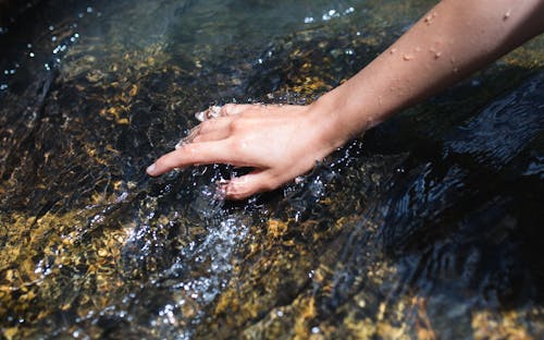 Hand in the Stream Water 