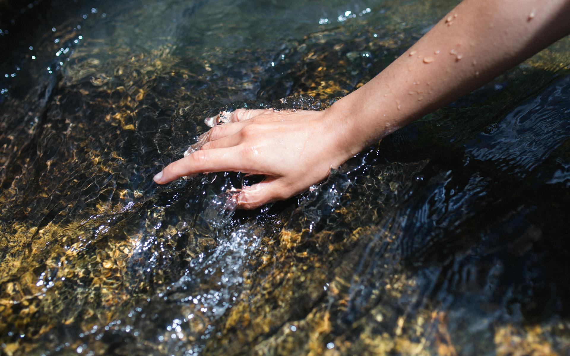 Hand in the Stream Water