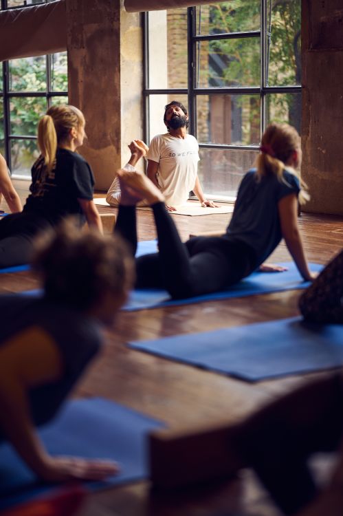 Yoga instructor leading a class with students practicing in a studio