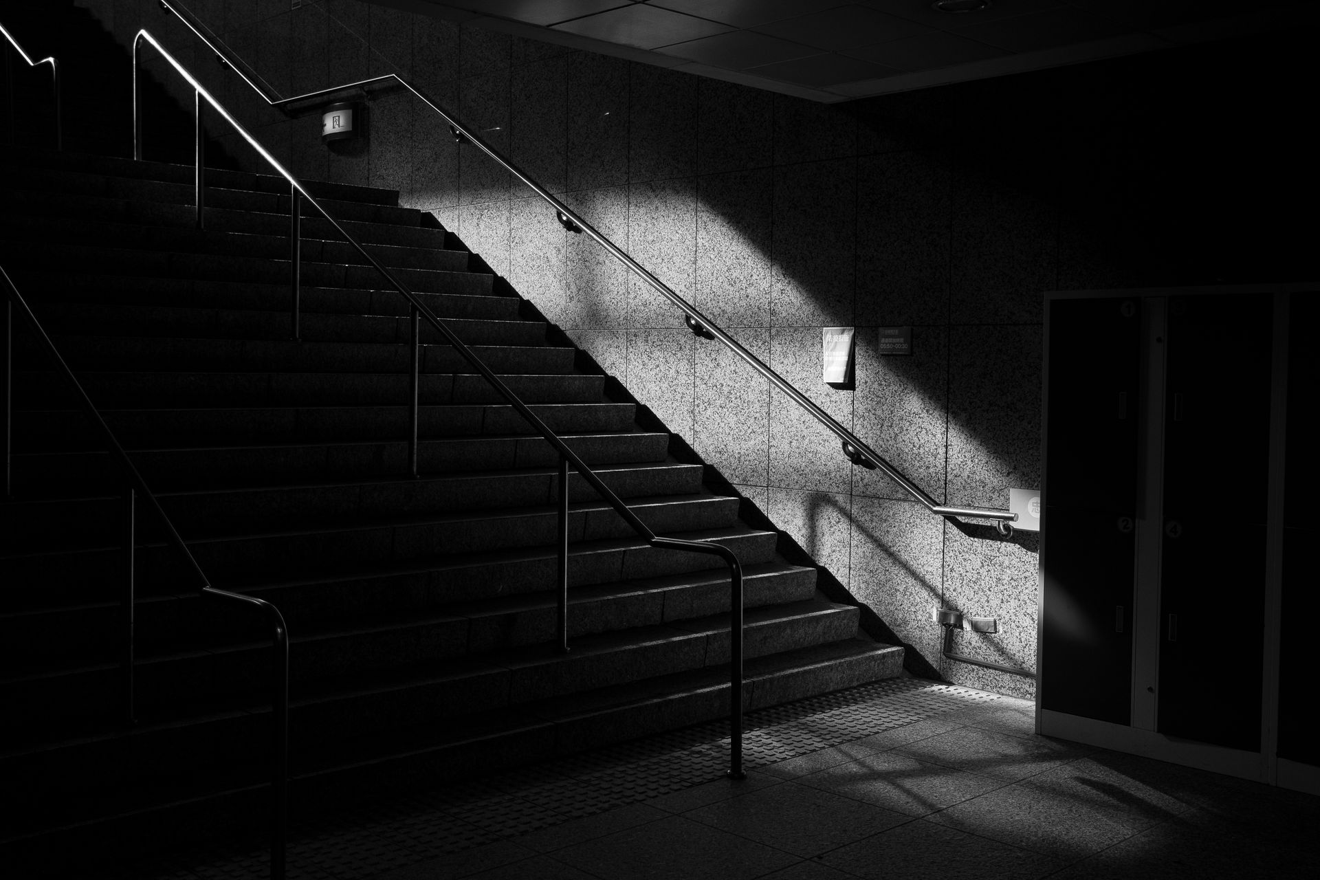 A black and white capture of a stairway with striking light and shadow contrast.