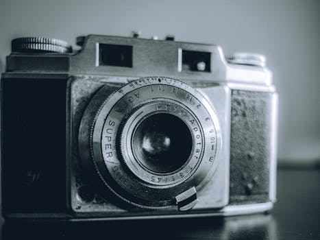 Close-up of a classic analog camera in black and white, showcasing vintage elegance.