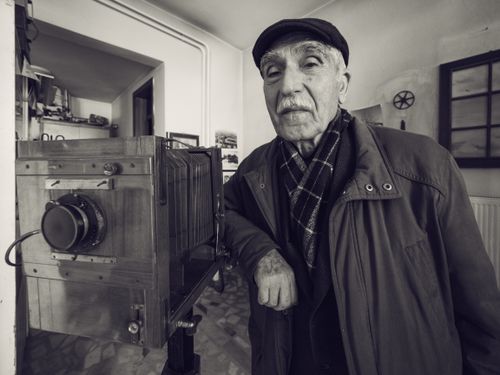 Free Senior man with vintage camera in a classic photography studio. Stock Photo