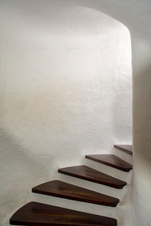 Free Elegant spiraling wooden staircase against white walls, showcasing minimalist interior design. Stock Photo
