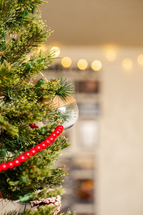 Free Close-up of a decorated Christmas tree with red beads and ornaments, indoors. Stock Photo