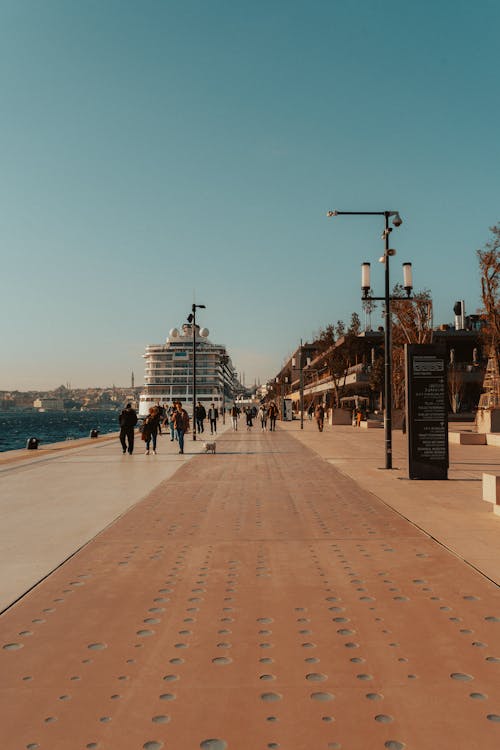 People Walking Down the Promenade by the Sea