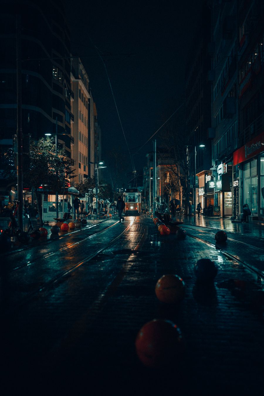 Tramvay ve ışıklı kaldırımlarla bir gece sokağı