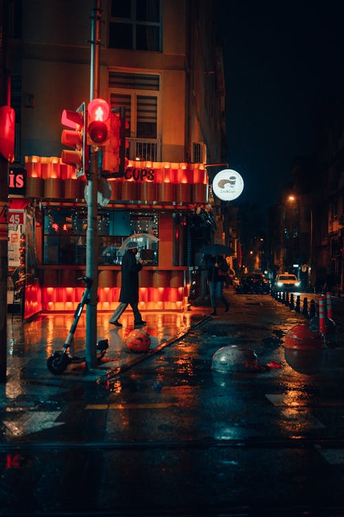 People wwalking on a Wet Street during Nighttime 