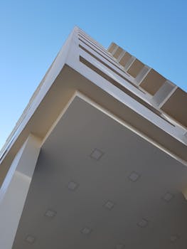 在晴朗的蓝天下，现代建筑的低角度视图展示了其几何设计