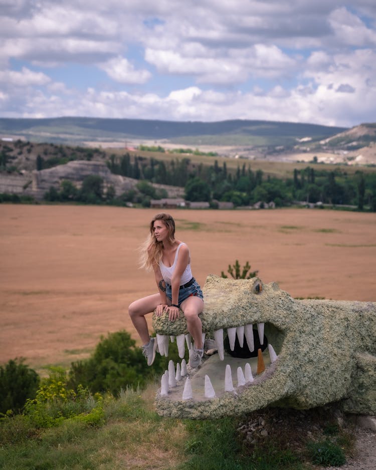 A Woman Sitting On A Crocodile Statue